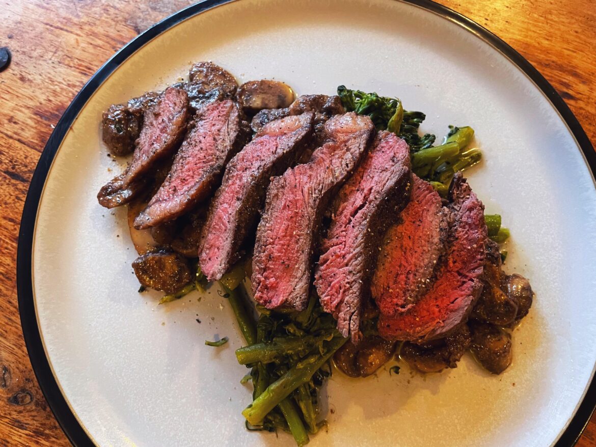 Rare rump steak on a bed of broccoli, asparagus and garlic mushrooms.