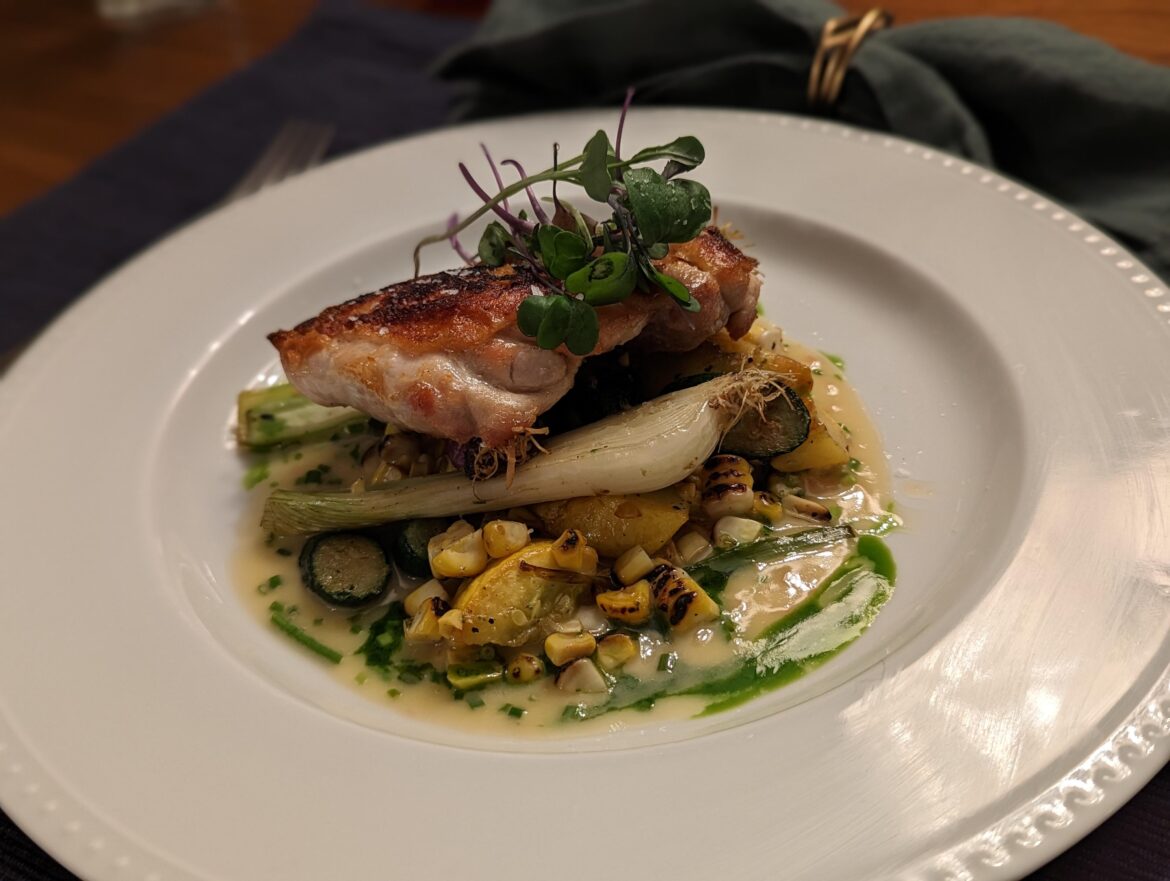 Pan seared chicken thigh, spring onions, charred corn and summer squash ratatouille, beurre blanc and chive oil