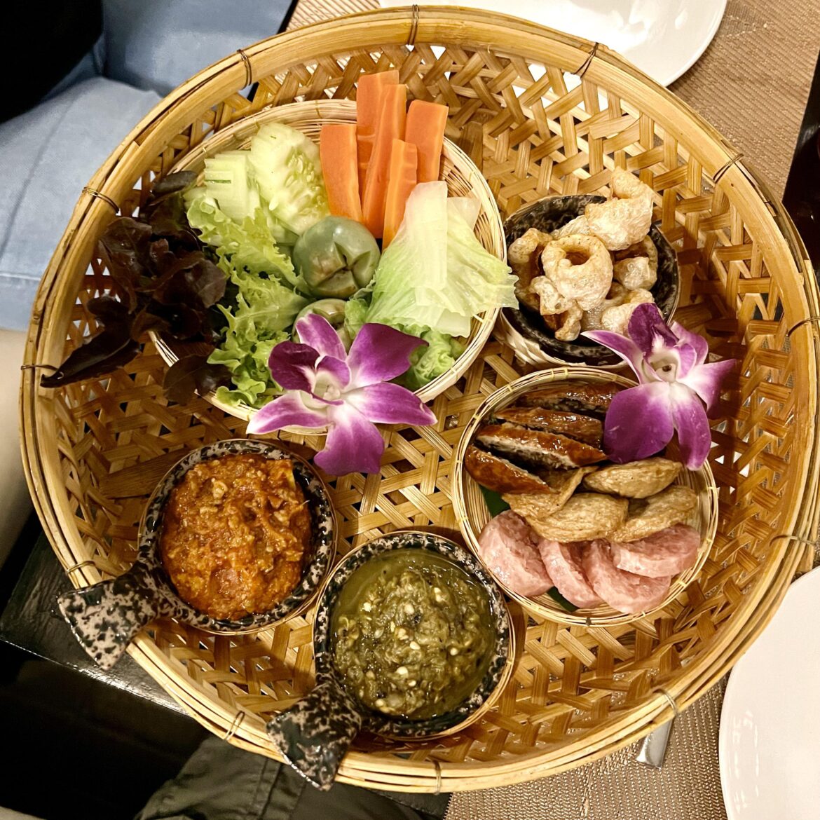 Various sausages, greens, and chili sauces in Chiang Mai