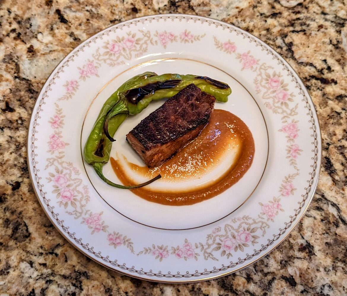 Butter finished steak with miso sauce and blistered shishito peppers