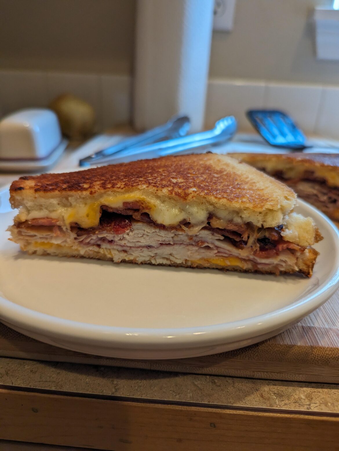Turkey, bacon, muenster and cheddar with hot damn raspberry reaper jam on grilled white