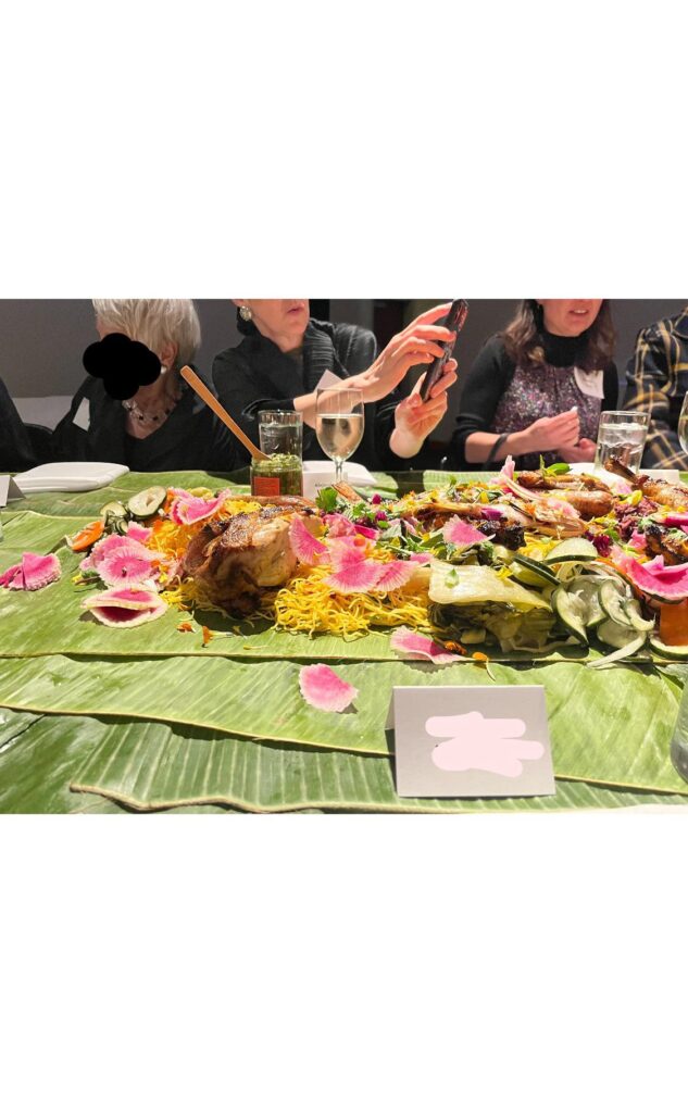 Family style meal on top of banana leaves, no utensils