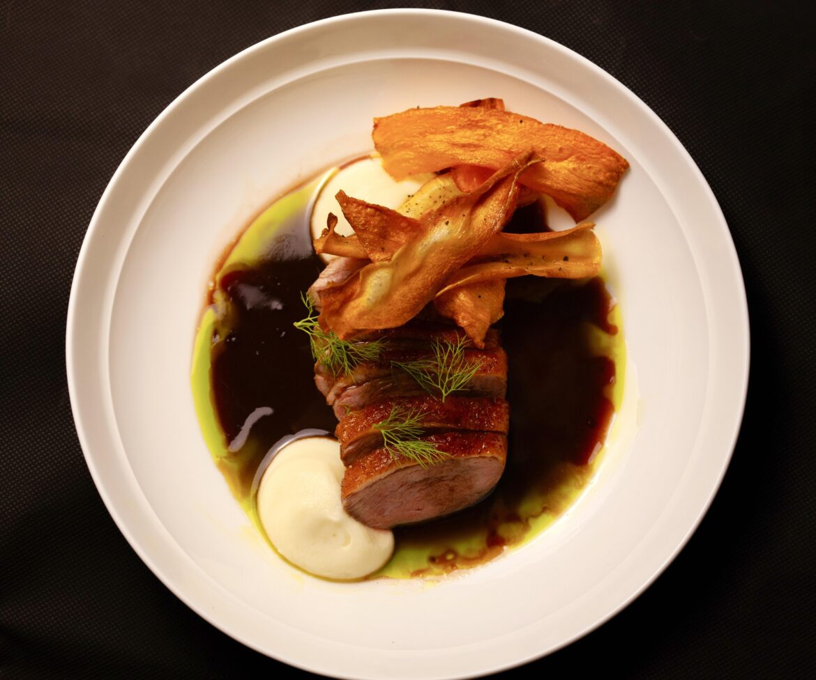 Duck, cauliflower purée, red wine jus, parsley oil and carrot and parsnip chips