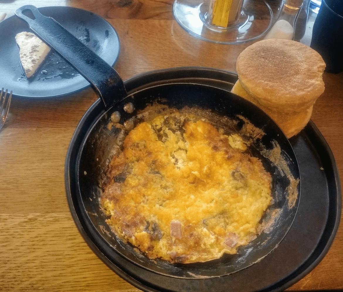 Overcooked eggs served in the pan that they were cooked in.