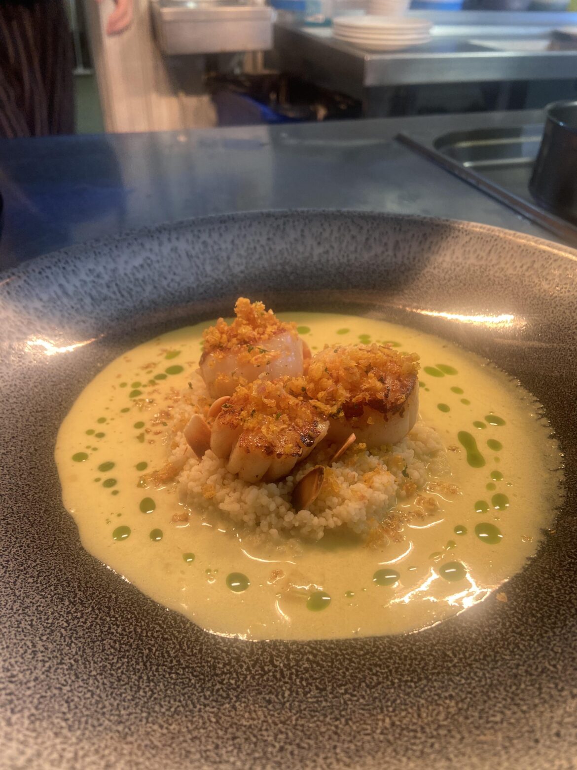 Scallops in curry sauce, coriander oil & bhaji crumb