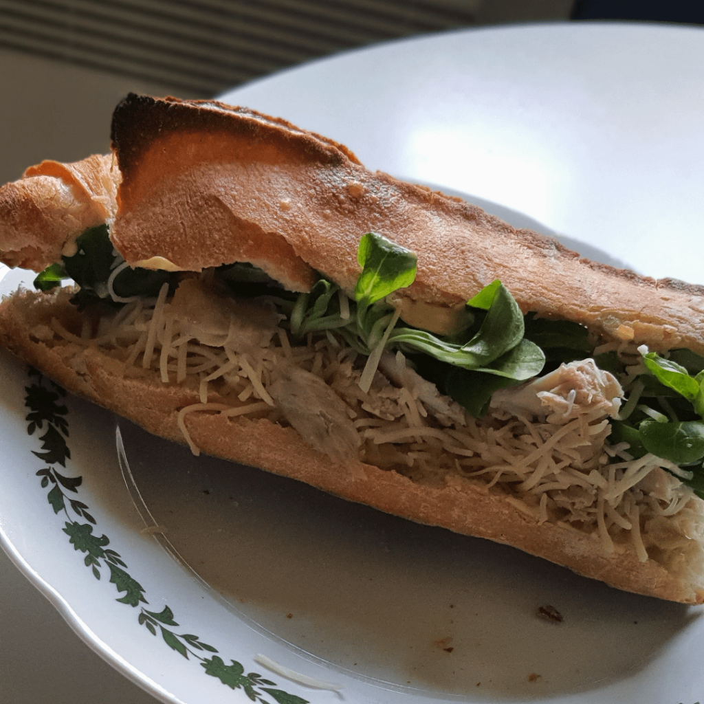 Sandwich made of chicken, lamb's lettuce, mustard and grated cheese