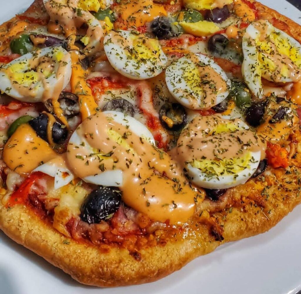 Argentinian style pizza topped with boiled egg, olives, ham, roasted red pepper. My friend from Albania taught me this, as her husband is from Argentina.