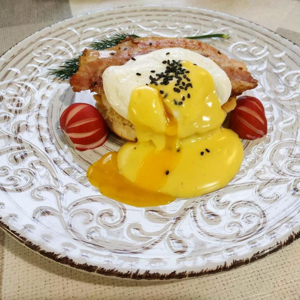 Eggs Benedict. Delicious 😋 A breakfast dish that is a sandwich with 🥚 poached eggs, bacon🥓 and hollandaise sauce