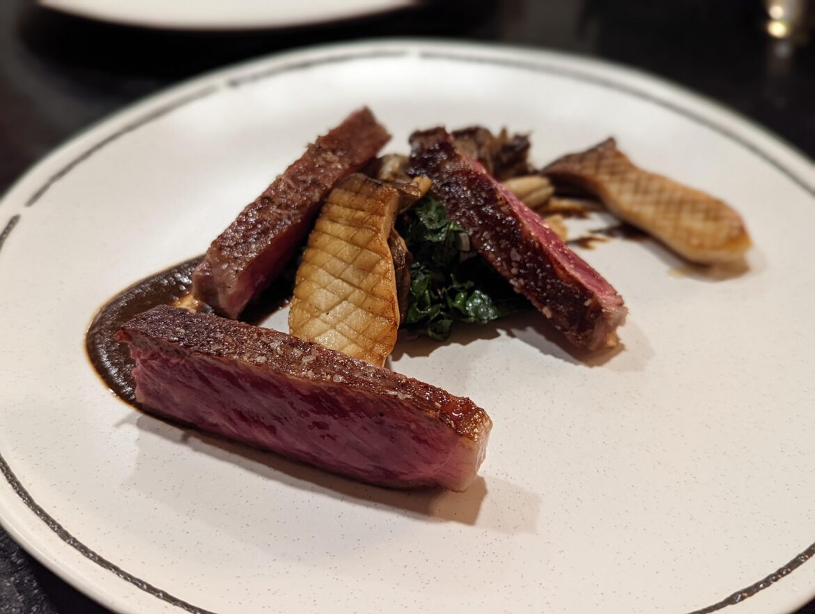 A5 wagyu with a black garlic sauce, beef fat fried king oyster mushrooms, and sauteed kale.