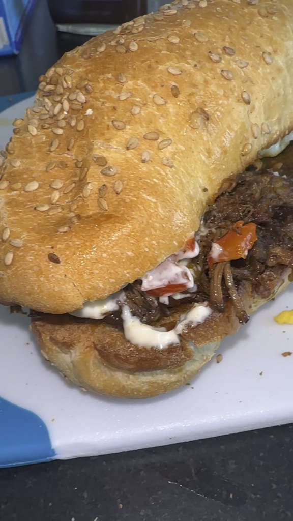 Beef sandwich with longaniza, eggs, cheddar and peppers.