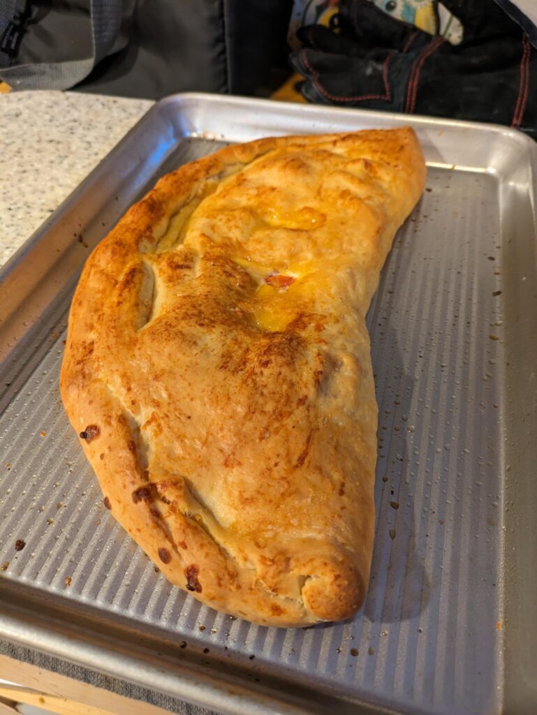 Calzone: Pepperoni, red onion, grape tomatoes + mozzarella, cheddar, and ricotta
