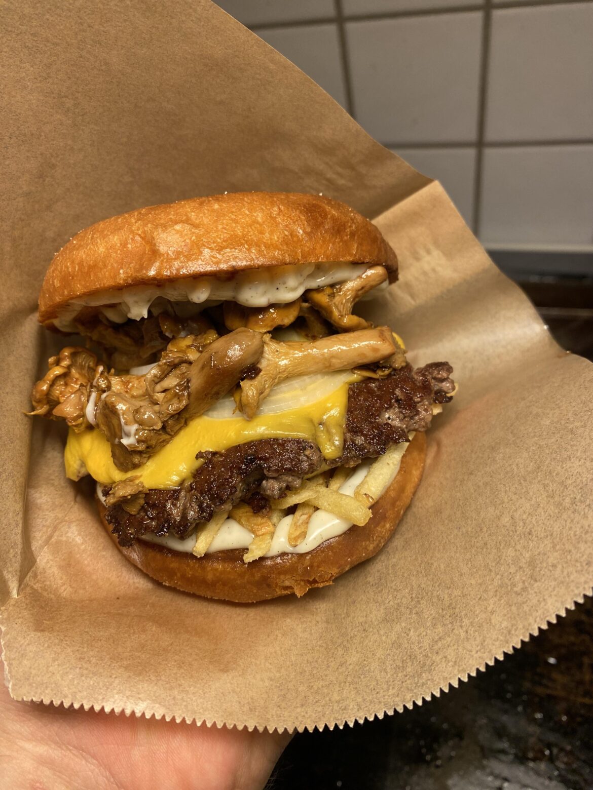 [Homemade] smashed burger whit butter fried chanterelles, truffle mayo, white onion, matchstick potatoes, 2 slices of cheese, 100g patty (70% chuck 30% sirloin), butter fried potato bun.