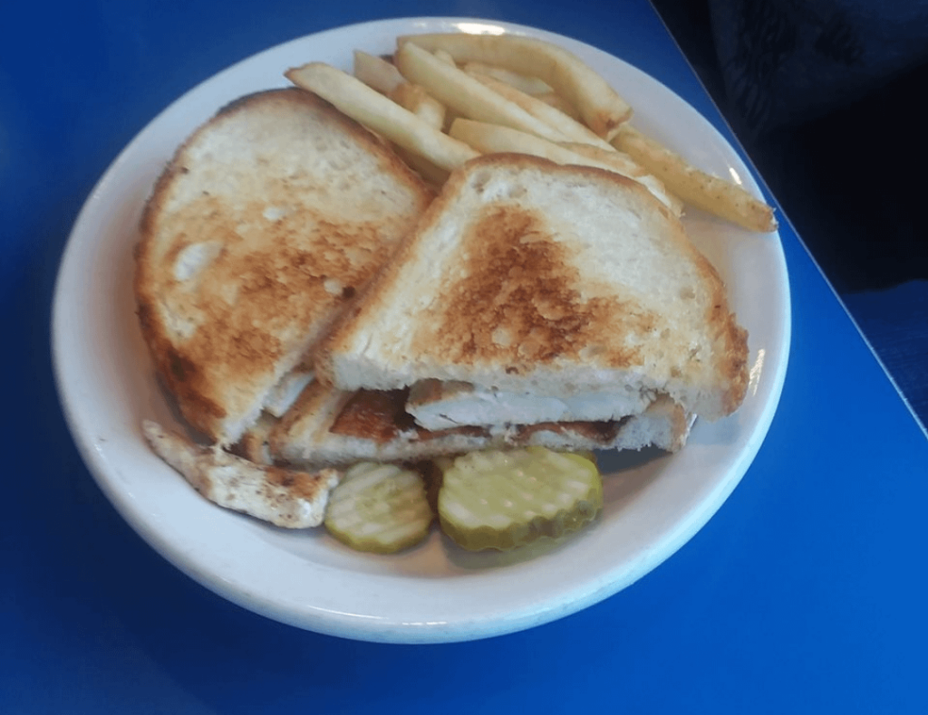 Grilled chicken sandwich with fries.