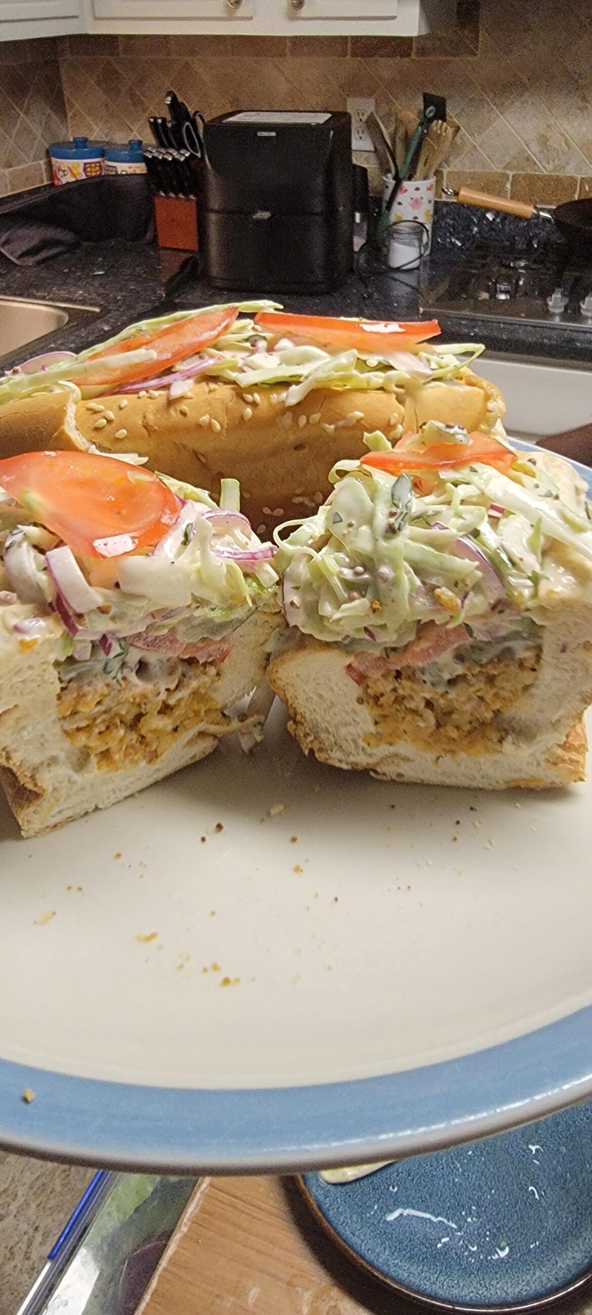 Boudin ball po' boy with cajun remoulade slaw, tomatoes, and pickles