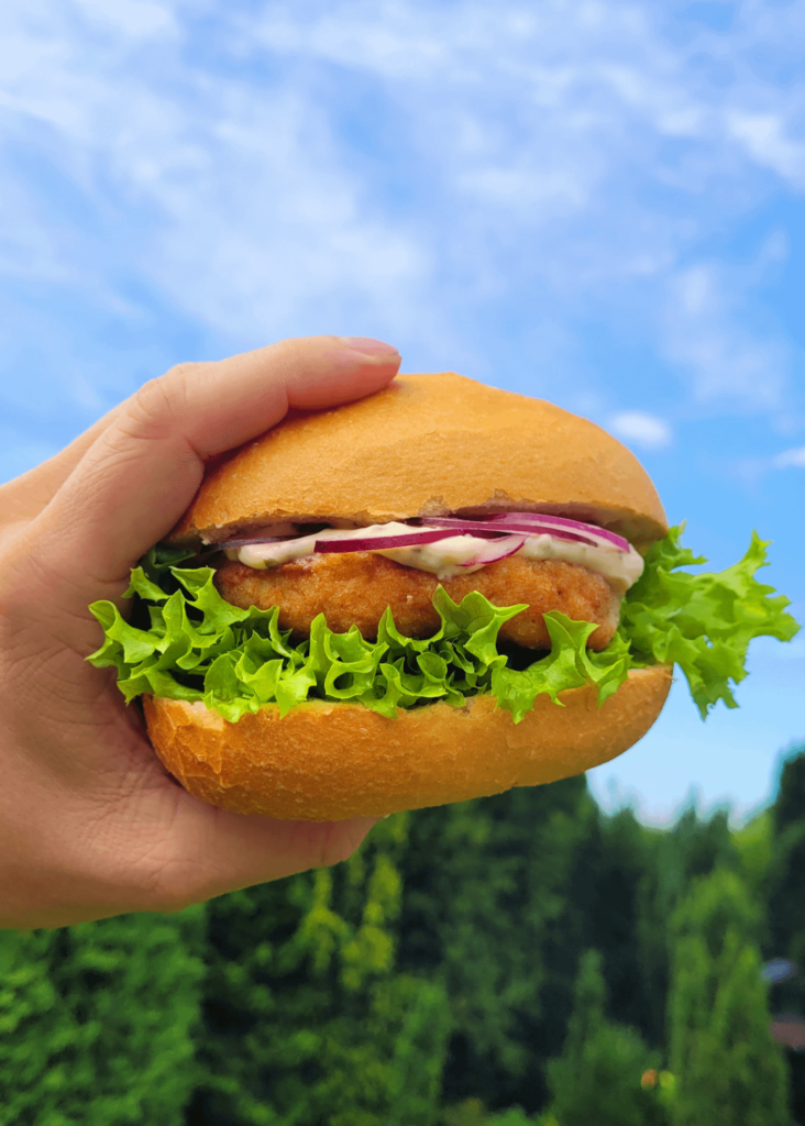 Fishcake on bread roll with lettuce, onions and tartar sauce