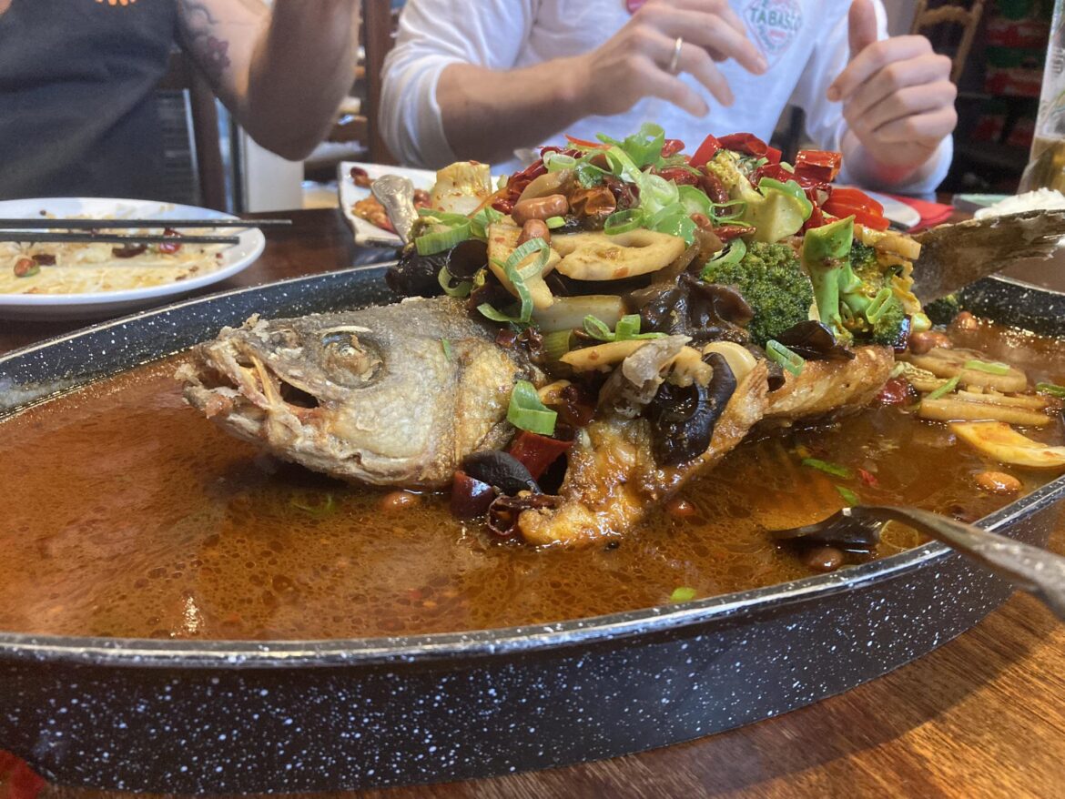 Epic whole spicy Sichuanese fish covered in chilli oil and all manner of vegetables