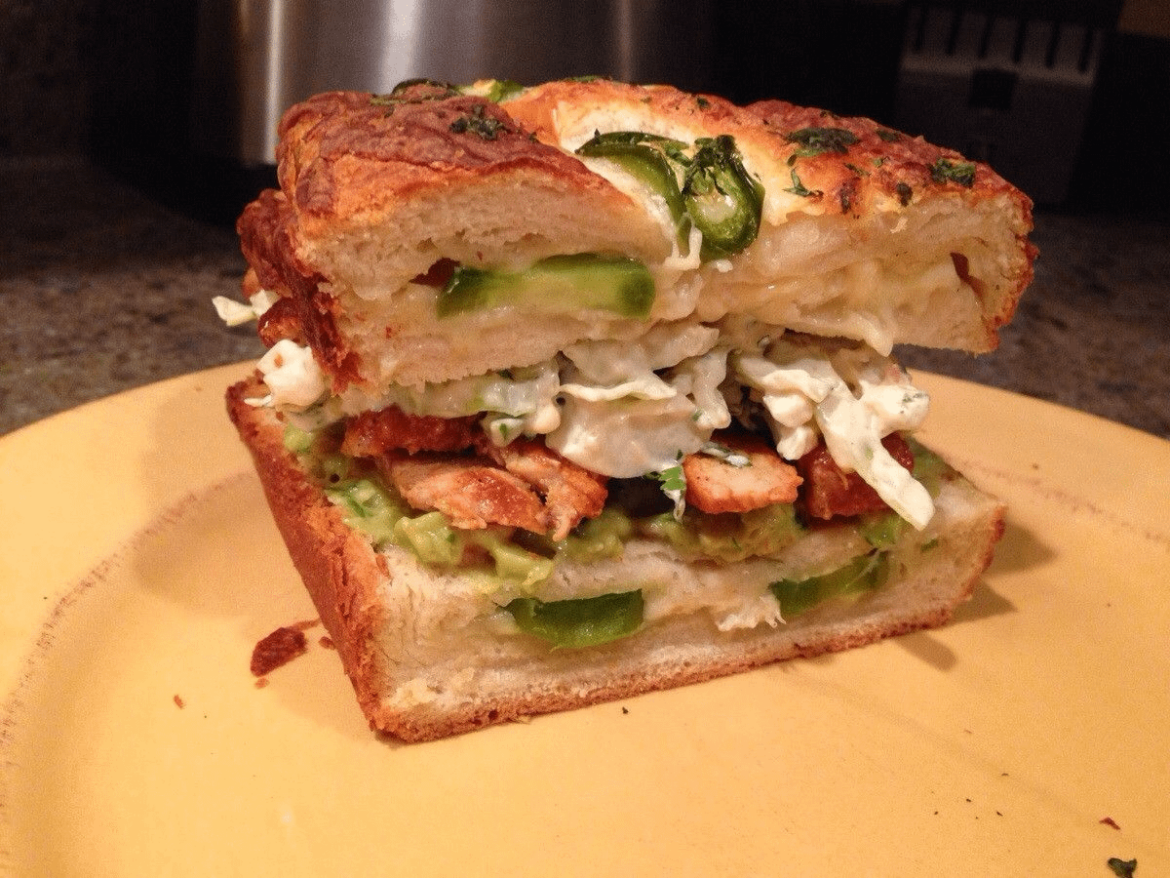Mexican sandwich. Cheesy jalapeño bread, guacamole, pork with red pepper sauce, and Serrano lime slaw