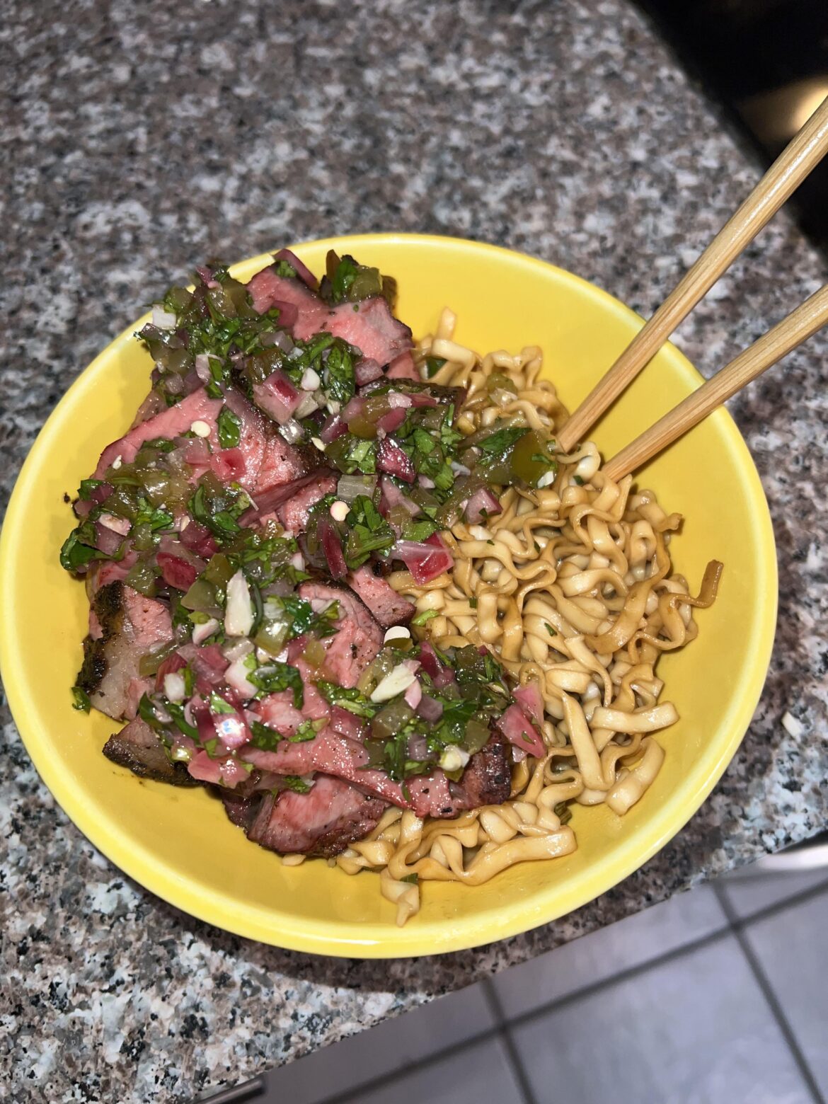 Tri-tip with hot Hatch Green Chile chimichurri over stir fried soy and scallion noodles.]