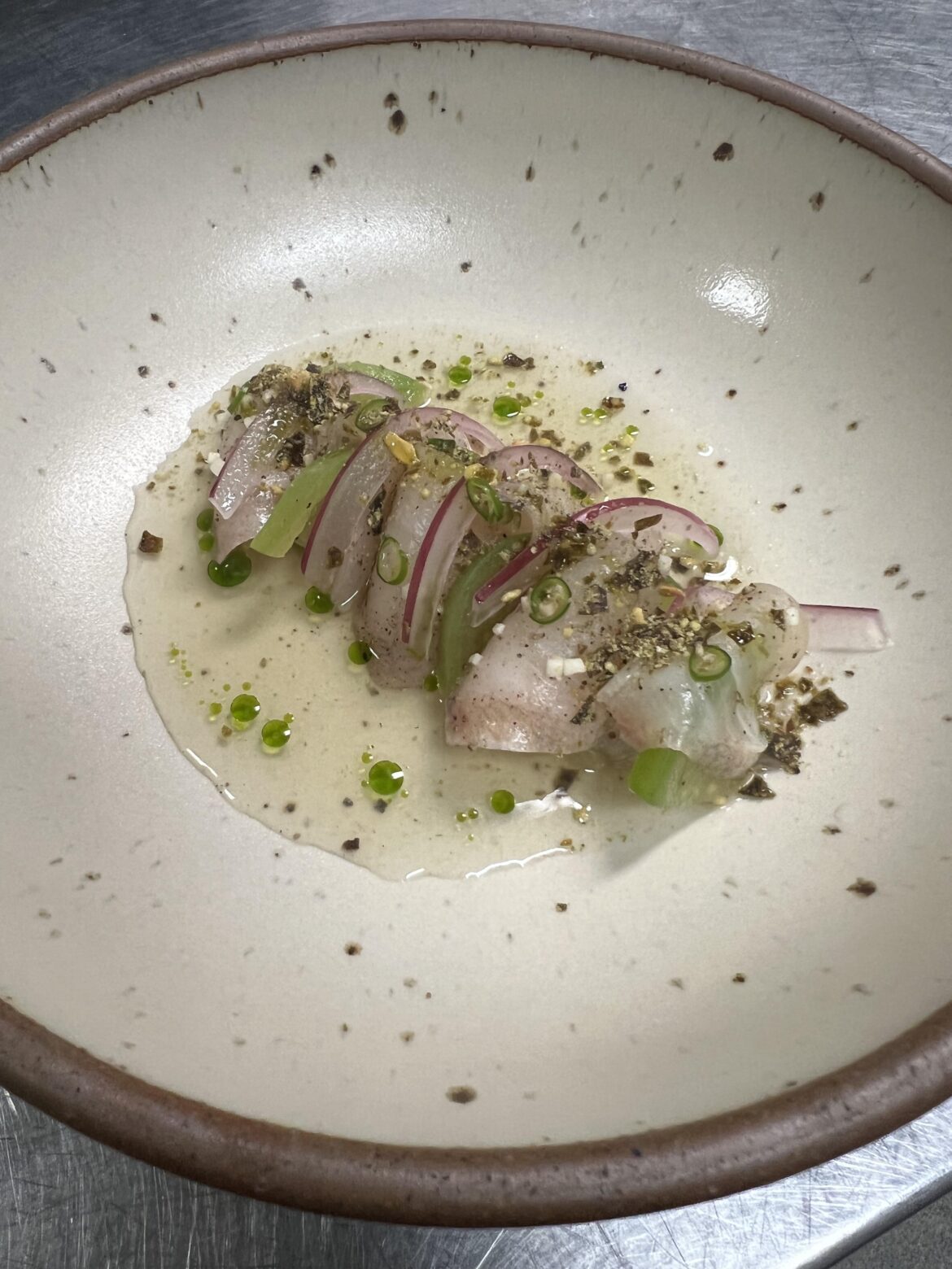 Hiramasa crudo with a tomatillo consumé, pickled tomatillo and red onion, pumpkin seed furikake