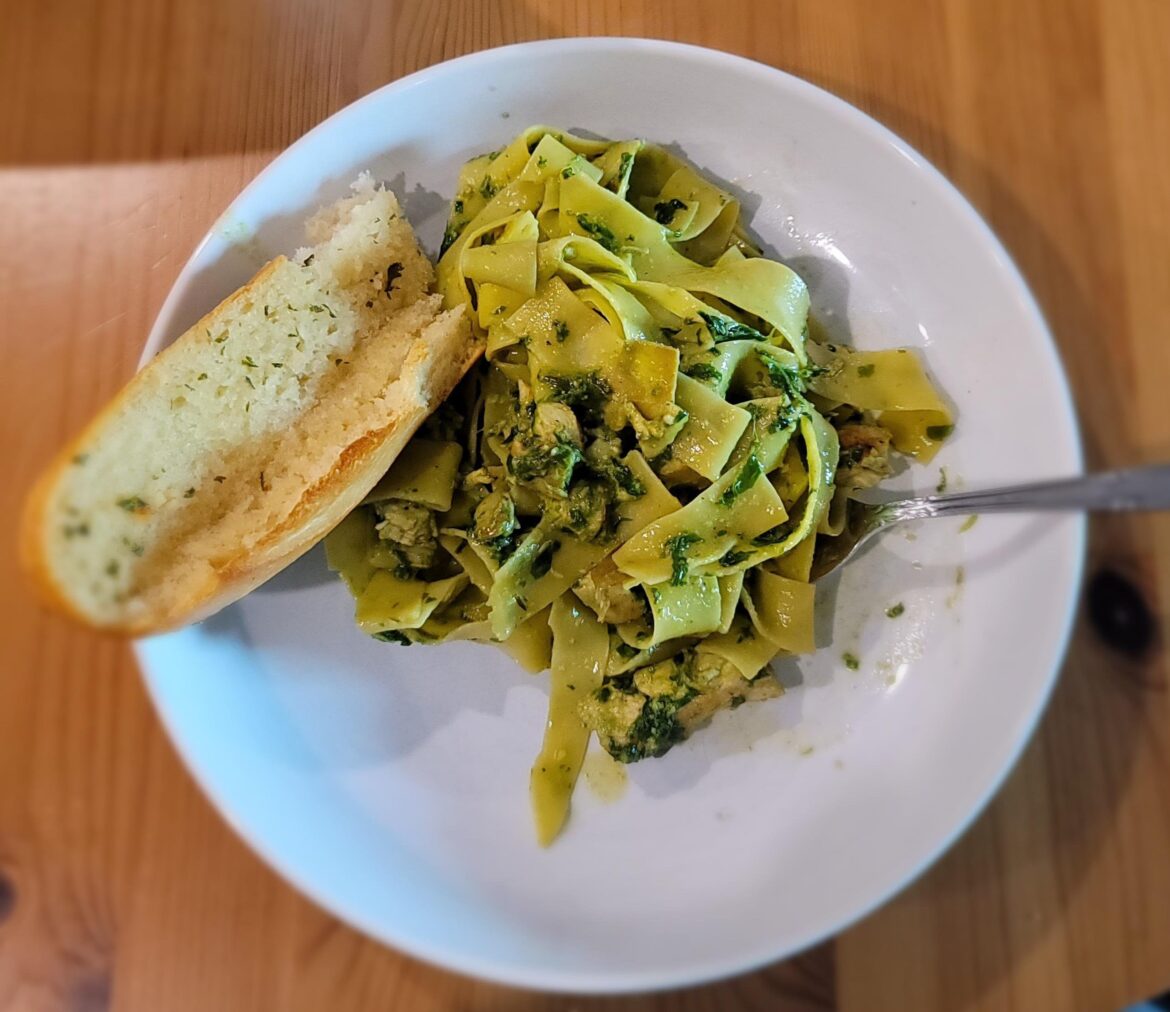 Pappardelle with Chicken, Artichoke Hearts, and Fresh Basil Pesto served with garlic bread.