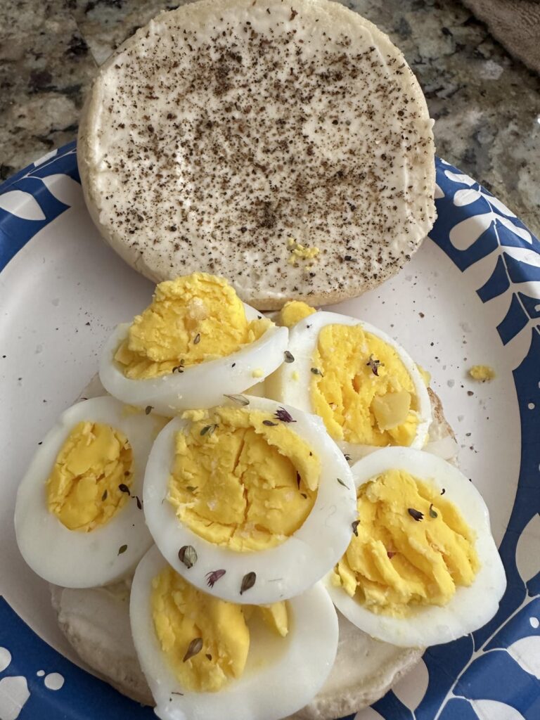 Fresh hot hard boiled eggs with mayo, onion, cracked pepper, and arctic thyme finishing salt on a sesame seed bun!
