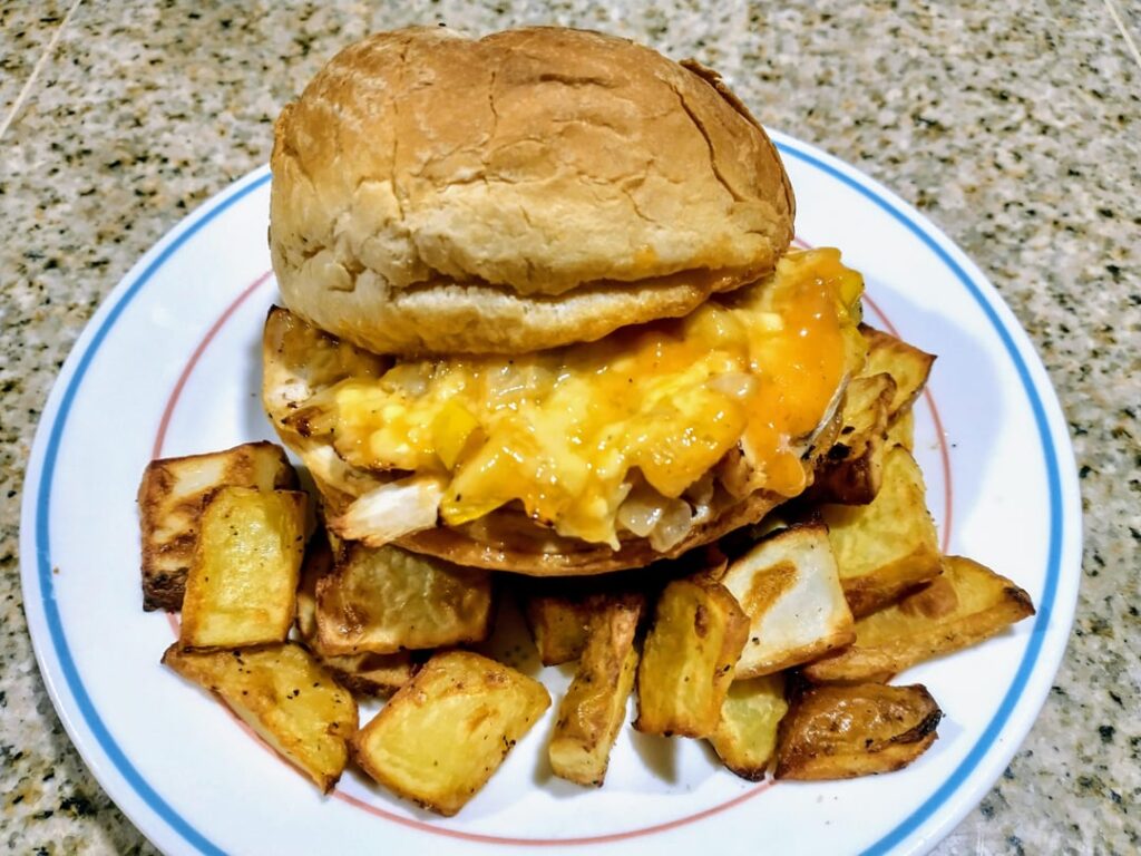 Homemade Chicken Sandwich - Roasted Chicken, Gruyère Cheese, Spicy Mayo, Sautéed Onions, and Shredded Romaine Lettuce on Potato Roll, with Home Fries.