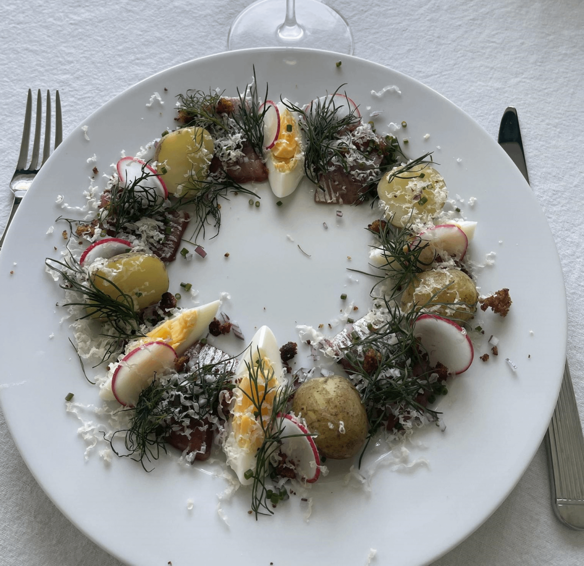Pickled herring with new potatoes, hard boiled egg, breadcrumbs and grated parmesan