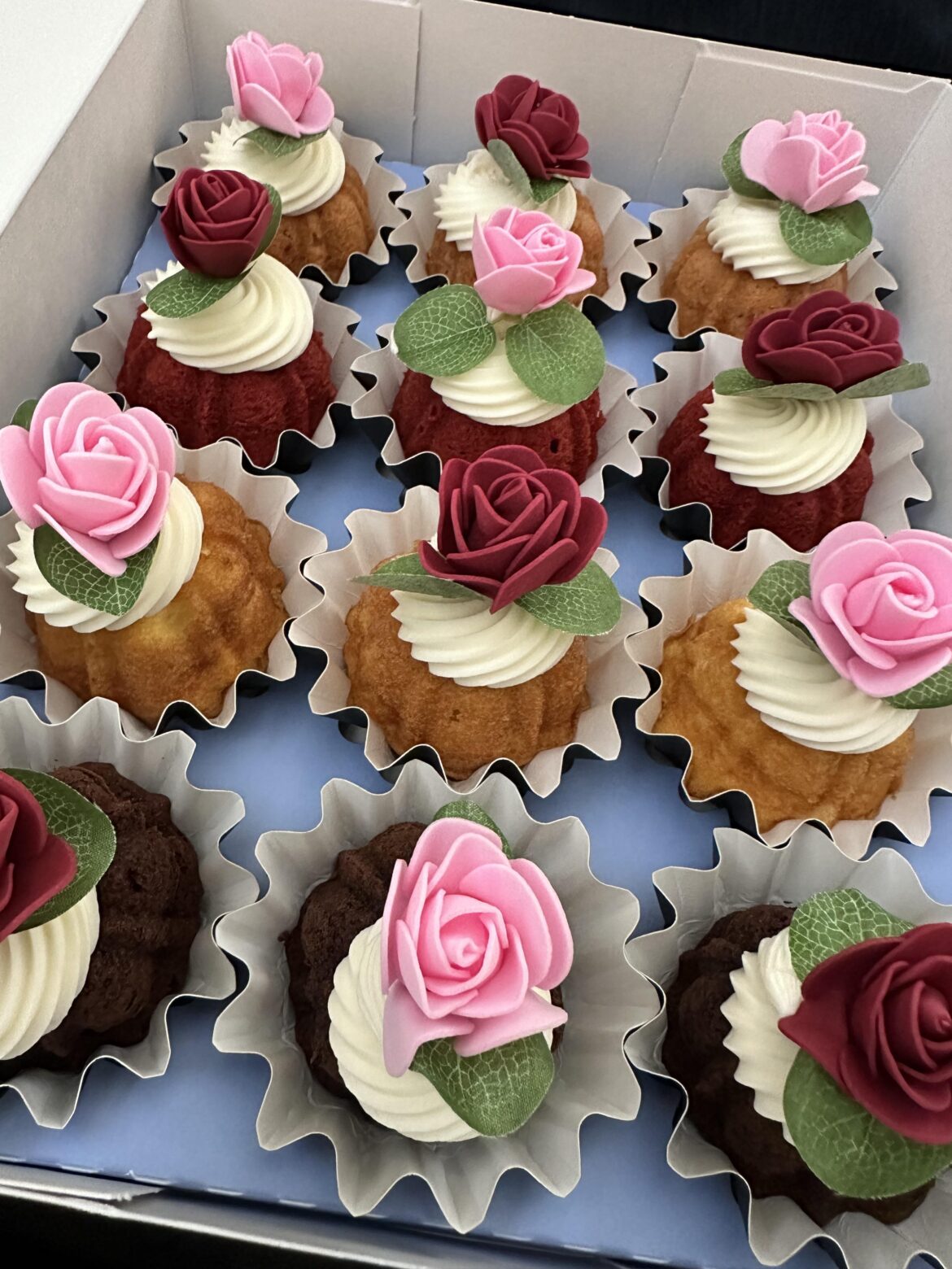 An assortment of mini bundt cakes with cream cheese frosting.