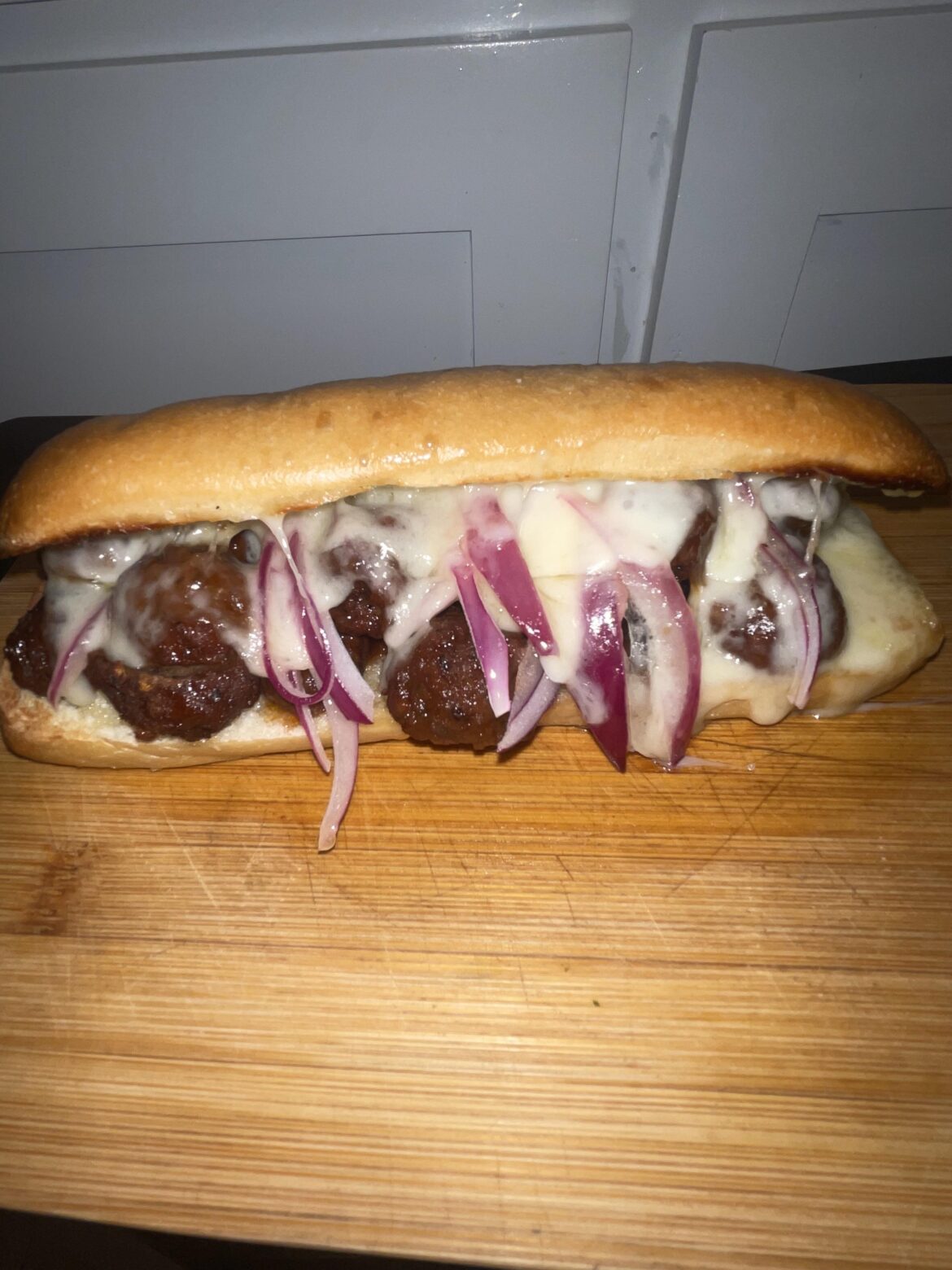 Slow cooker meatballs, Swiss cheese and red onions.