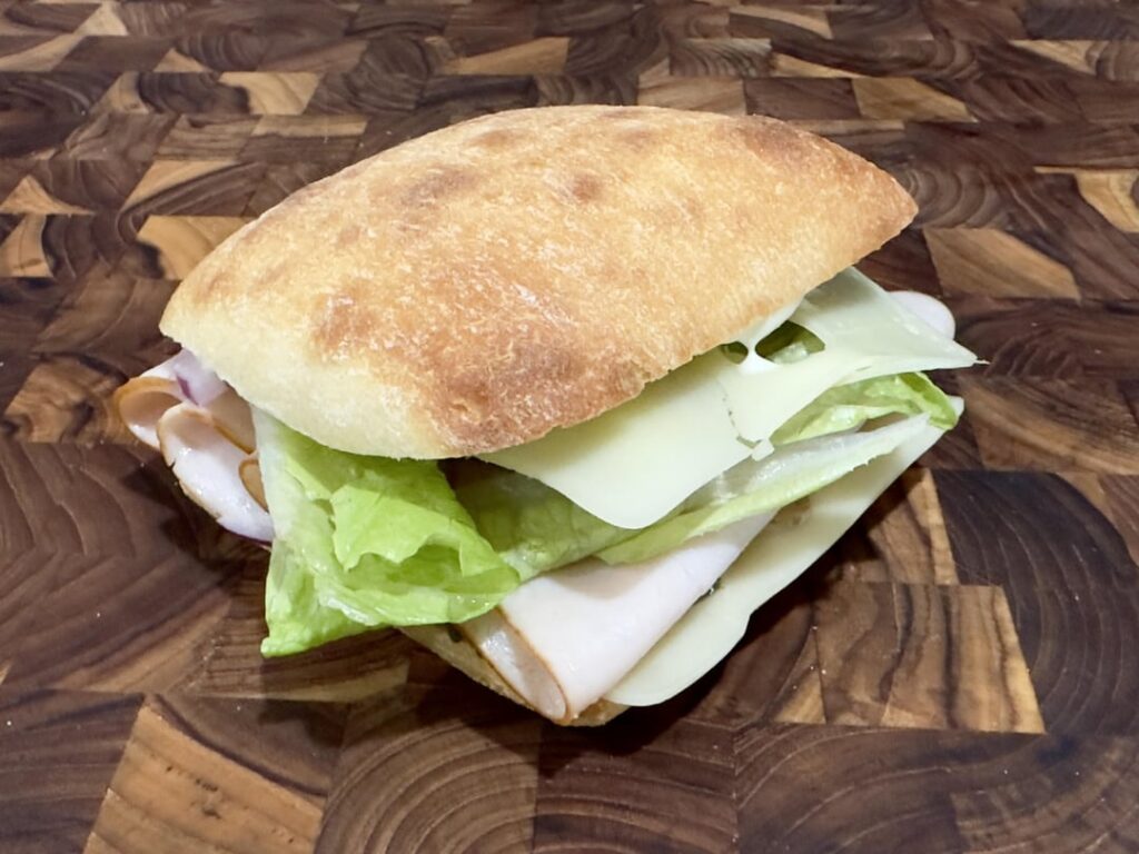 turkey and swiss on a warmed ciabatta w/ lettuce. red onion, homemade pickle, dijon and creamy italian dressing