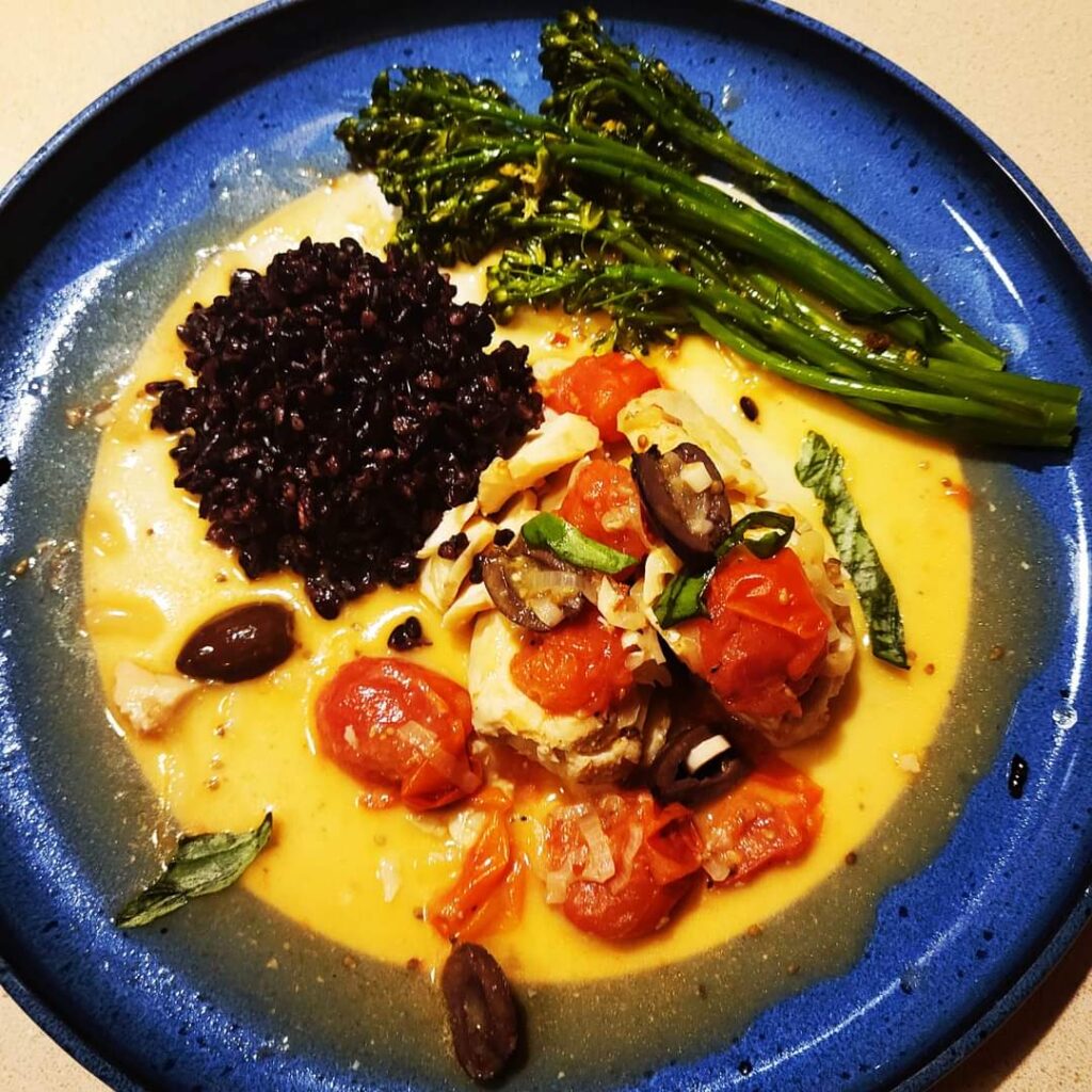 Tomato and garlic poached cod with black rice and sautéed broccolini.