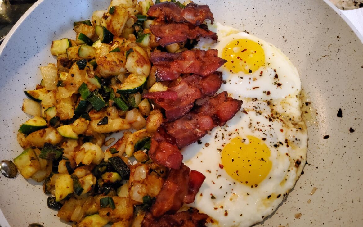 Weekend breakfast. Potato and zucchini hash with crispy bacon and sunny side up eggs.