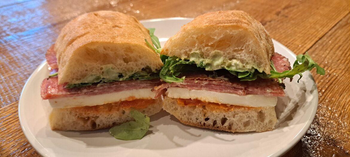 Soppressata, Peppered Salami, Crispy Prosciutto, Heirloom Tomato Jam, Mozzarella, Pesto Aioli, and Arugula on Ciabatta