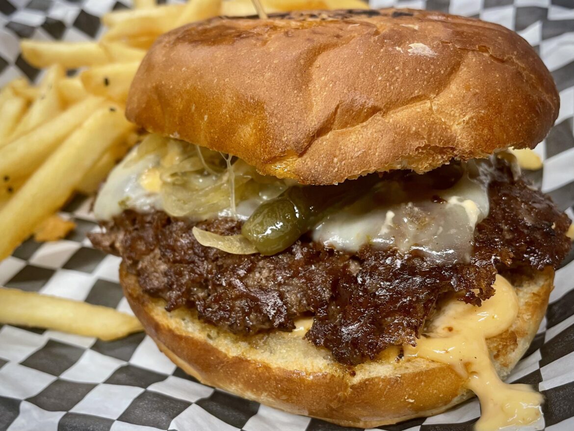 Burger with pepper jack, sautéed onions and serrano peppers, and chipotle aioli