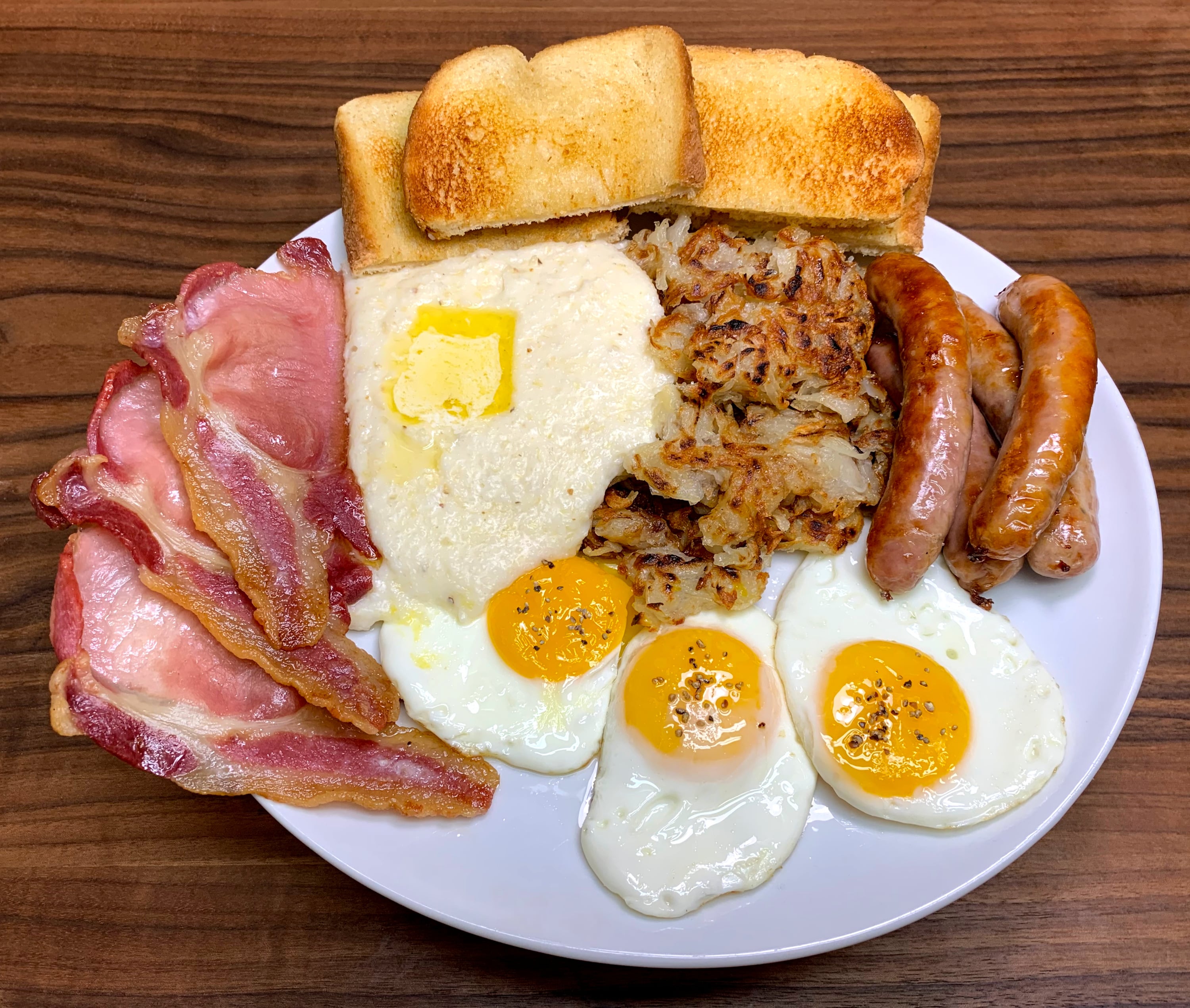Rashers and Chipolata Sausages with Cheese Grits, Hash Browns, Eggs and