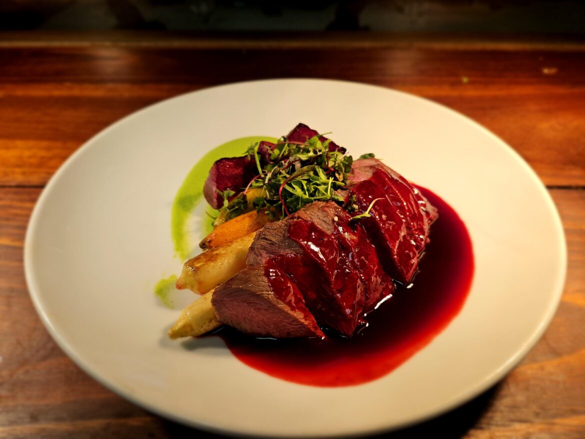 Flat iron with wine poached baby carrots and beets, beet veal glace and pee puree.