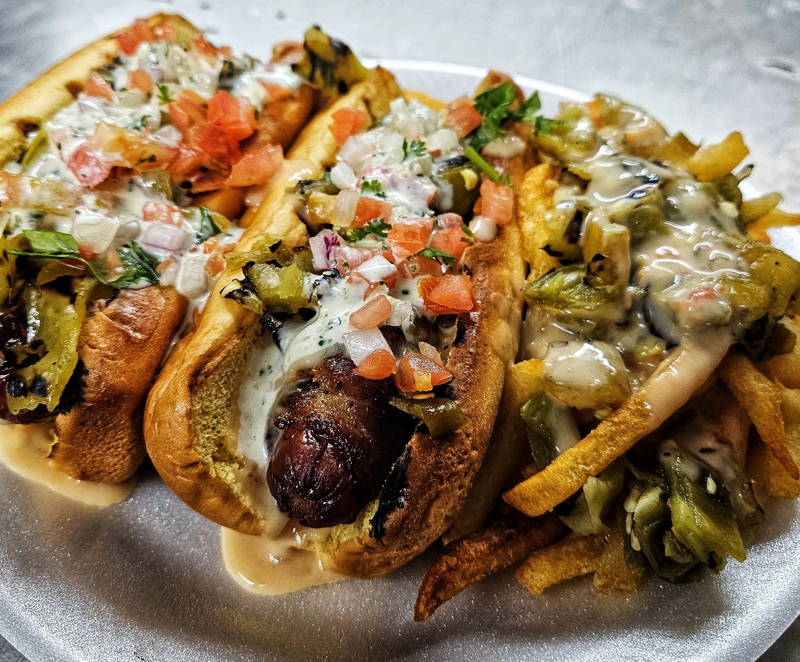 Baconwrapped hot dogs with queso, roasted Hatch chiles, pico de gallo