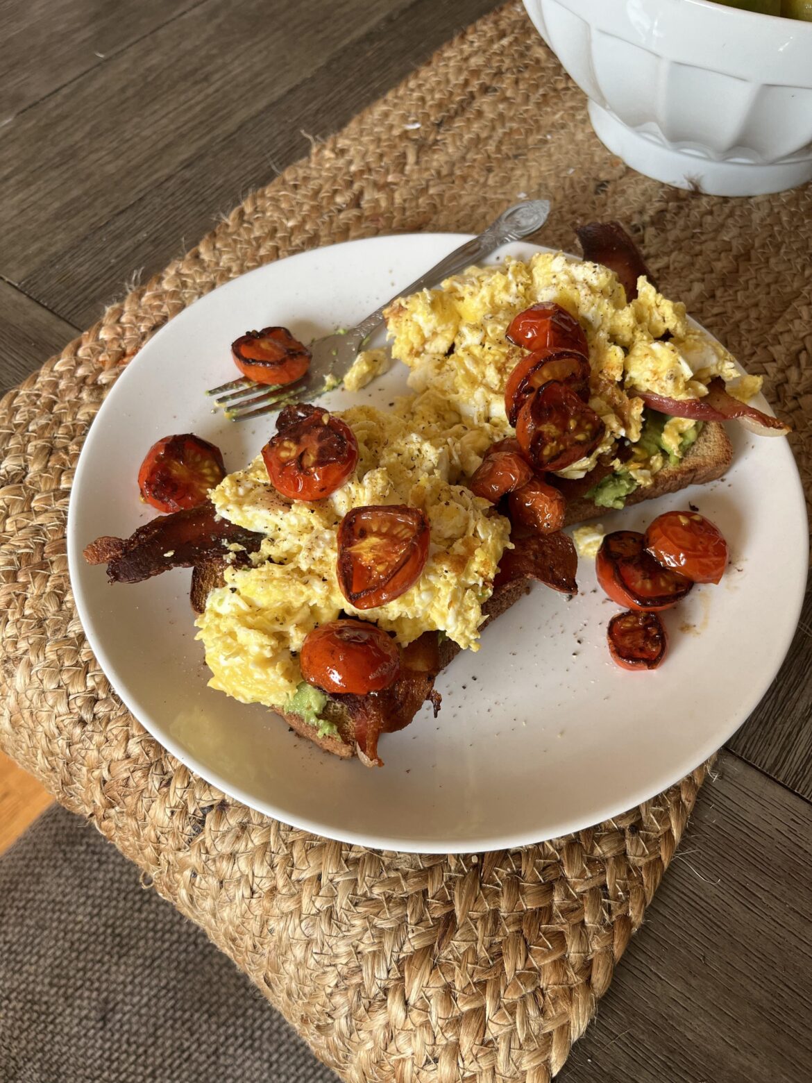 Scrambled eggs on avocado toast with bacon