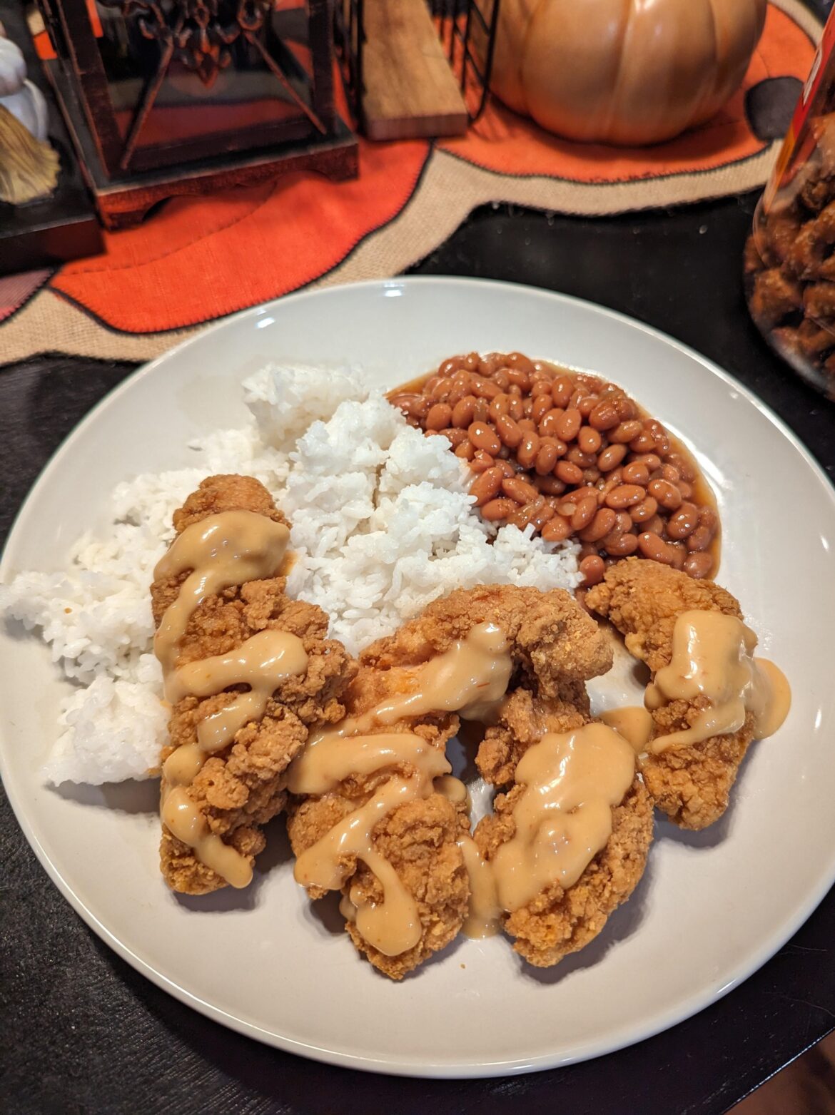 Jasmine rice, baked beans, chicken strips, any choice of sauce. Probably about a $5 meal at most, and it's filling. I have not gotten tired of it once.