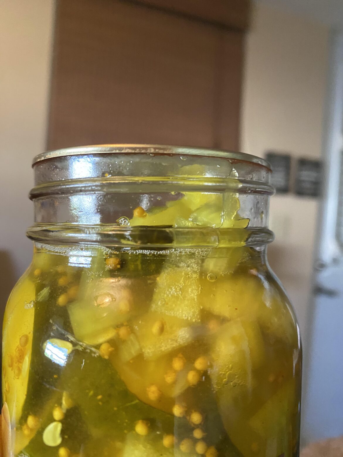 Hi! Water bath canned bread and butter pickles from the Ball Book for Home Preserving for the first time. But the pickle mixture its not all under the brine. Is this normal? Did I messed up?