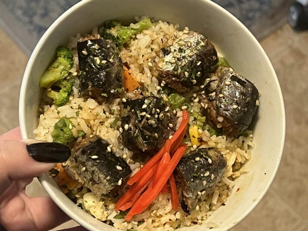 Spicy sardine rice bowl with vegetables, soy sauce sardines, chili crisp, furikake, and pickled ginger