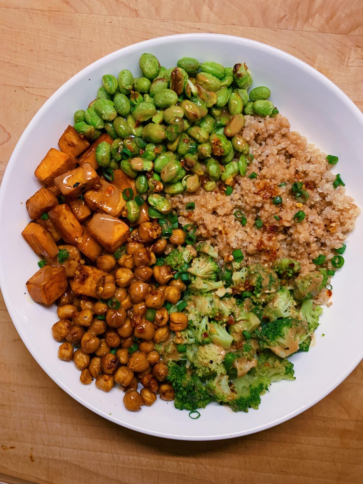 thai peanut sweet potato bowl 😮‍💨 quinoa, roasted and seasoned sweet potato + chickpeas, edamame and steamed broccoli. drizzled with peanut sauce and (completely unnecessary, but VERY GOOD) trader joe’s chili crunch 🍠🌶️🥜