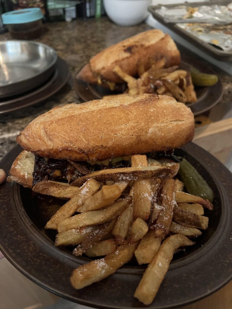 Steak sandwich with truffle fries and a bubbies pickle Steak sandwich with truffle fries and a bubbies pickle