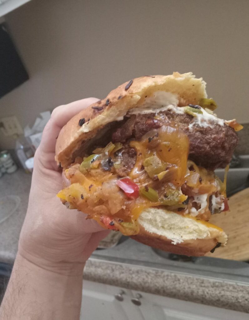 Double Bacon Cheddar Angus Burger On An Onion Roll With Hot Peppers, Mayo, And Jalepeno Ketchup.