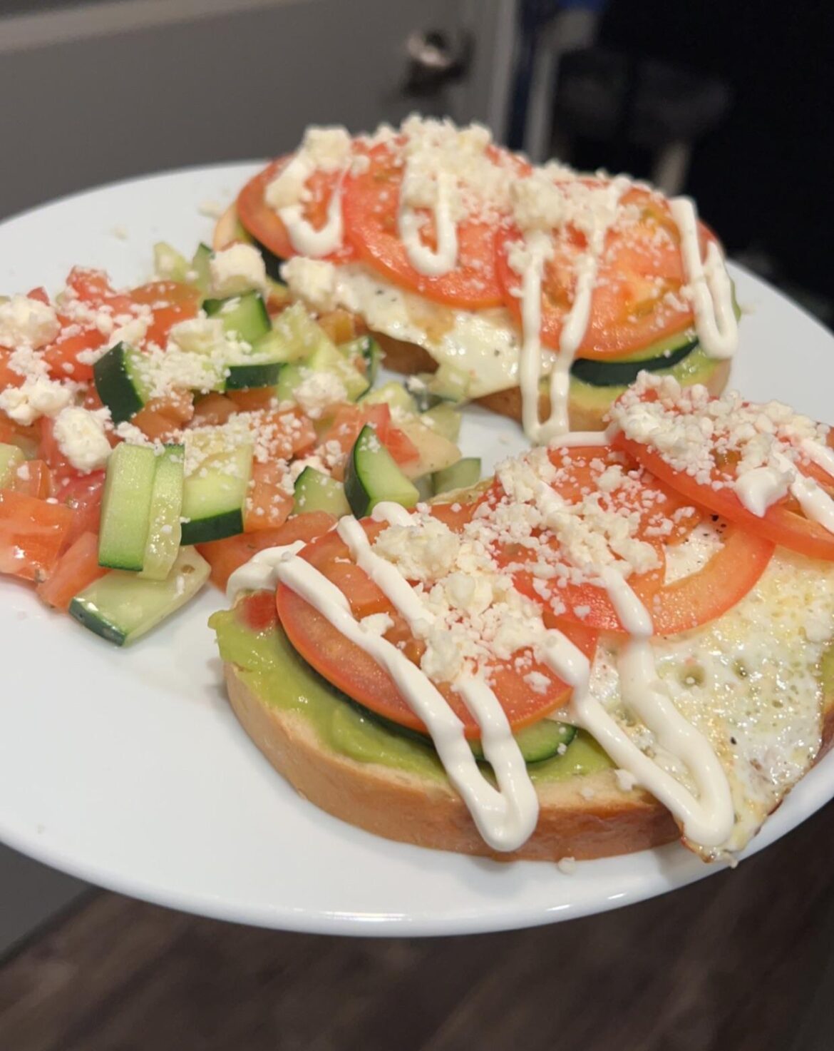 Feta topped avocado toasts with eggs and cucumber tomato salad