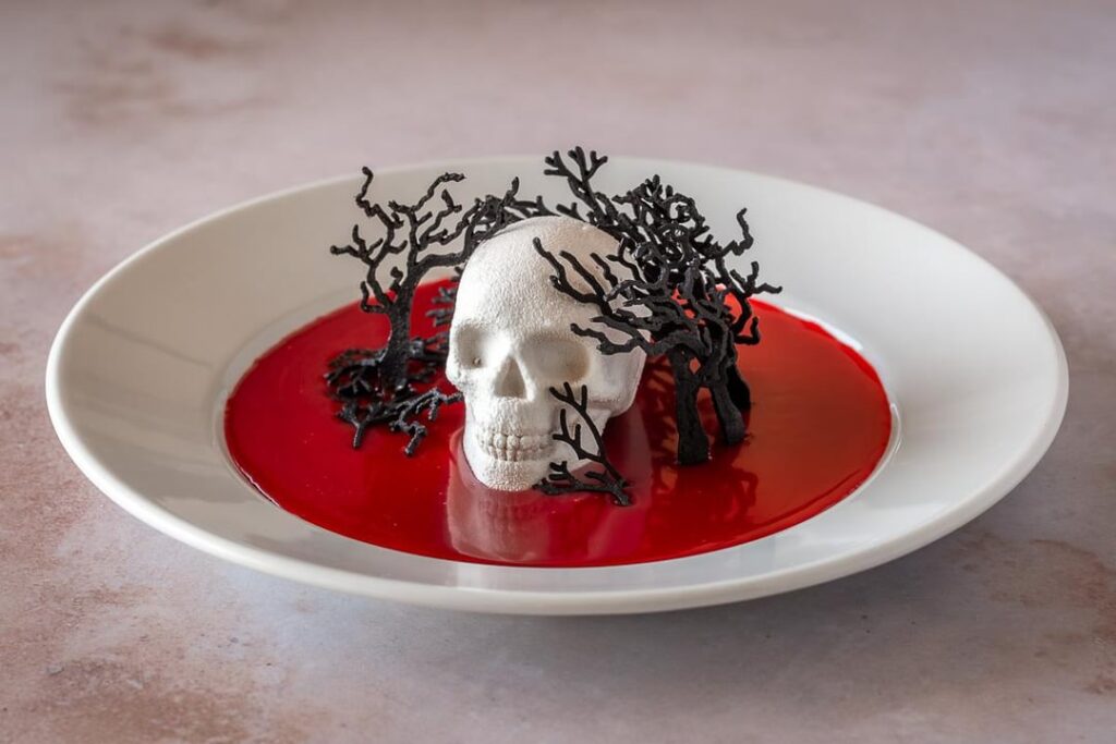 White Chocolate Covered Pumpkin Cheesecake Mousse Skulls with Maple Caramel Sauce and Black Cocoa Tuiles - Happy Halloween!