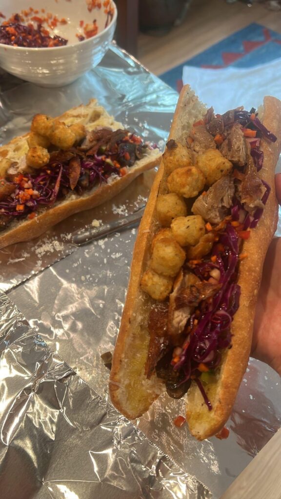 Secret steps to making a Duck confit, sautéed mushrooms, red cabbage red pepper carrot Granny Smith apple slaw, tater tots, parmigiana reggiano baguette sandwich