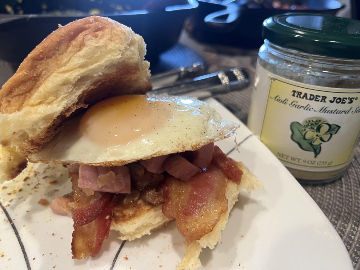 Bacon, ham, Trader Joe’s garlic aioli mustard on toasted pan deal bread, traditional Filipino breakfast bread, with an over easy egg 🥚