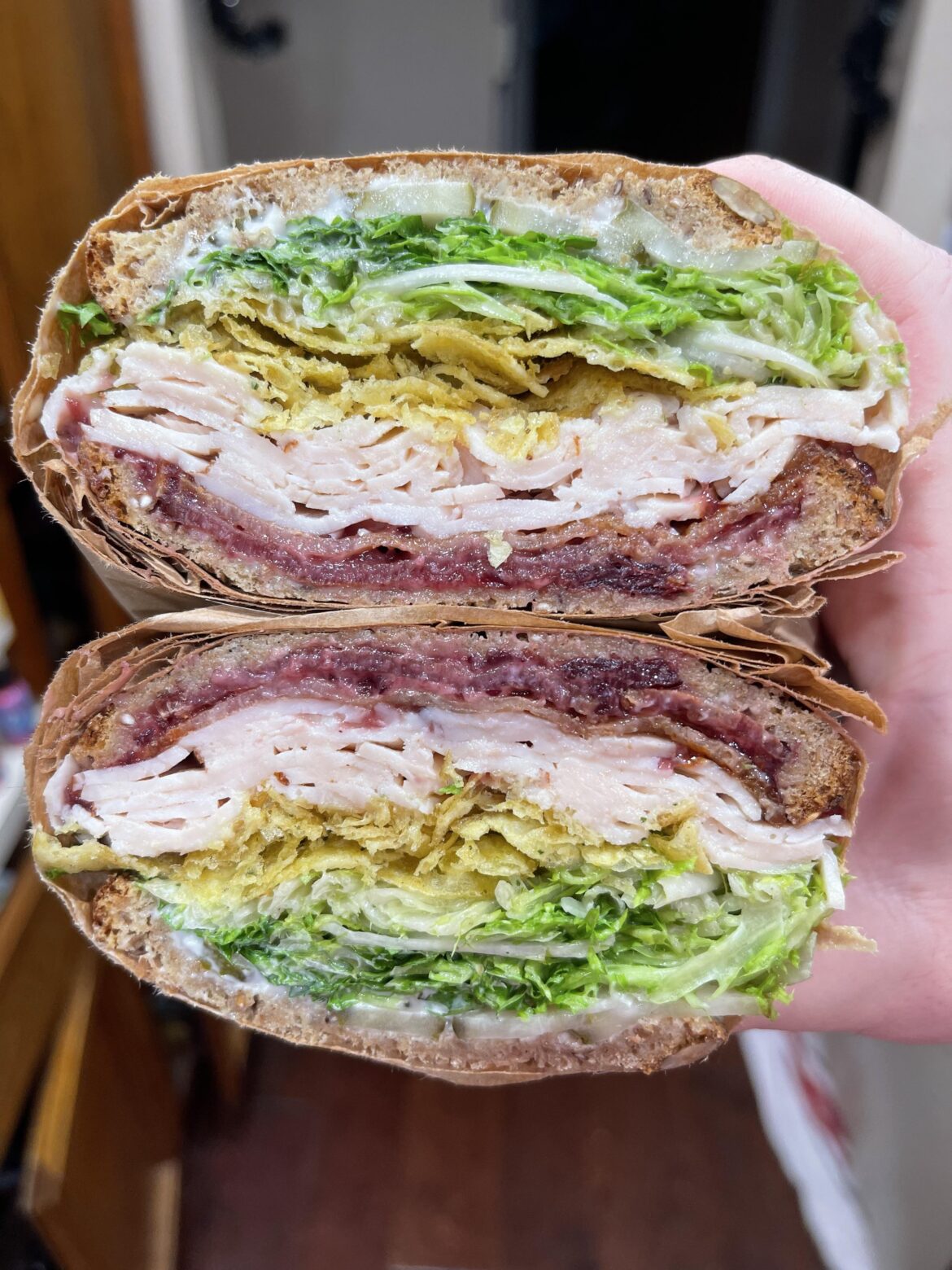 [homemade] Seedy whole wheat, turkey, bacon, TJ’s stuffing flavored kettle chips, honey Dijon frisée, dill pickles, mayo, cranberry spread