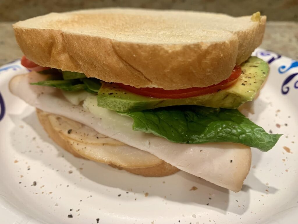 Turkey, provolone, avocado, tomato, lettuce, mayo, mustard, S&P. I have so much leftover Thanksgiving turkey, but decided to go with deli slices instead.